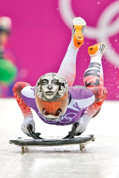 În proba de skeleton concurenţii coboară cu sania, pe burtă, cu capul înainte