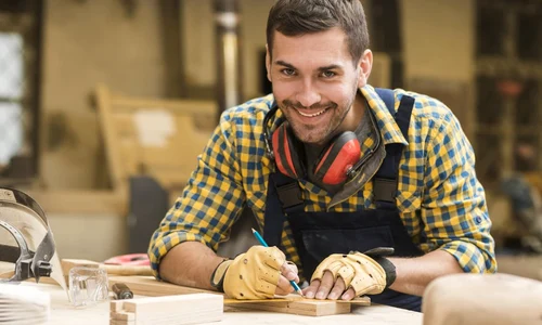 smiling portrait male carpenter taking measurement with ruler pencil wooden block jpeg