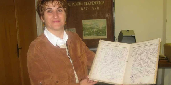 Arhivistul prezintă documentul în care este înscrisă data de naştere a lui Perpessicius