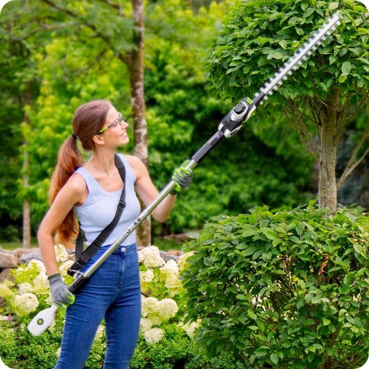 Femeie care tunde vegetația din grădină cu o foarfecă electrică Foto Gtech.com