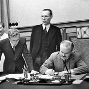 Veaceslav Molotov semnează Pactul de neagresiune cu Germania nazistă, în prezența lui Iosif Stalin (foto: Wikimedia Commons)