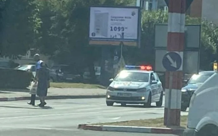 Poliţistul a ajutat-o pe bătrână să treacă strada FOTO: Facebook
