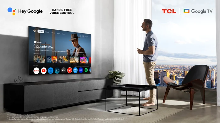 Bărbat analizând specificațiile unui televizor TCL de mari dimensiuni în livingul său Foto eMAG