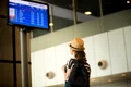 woman front airport flight information panel jpg