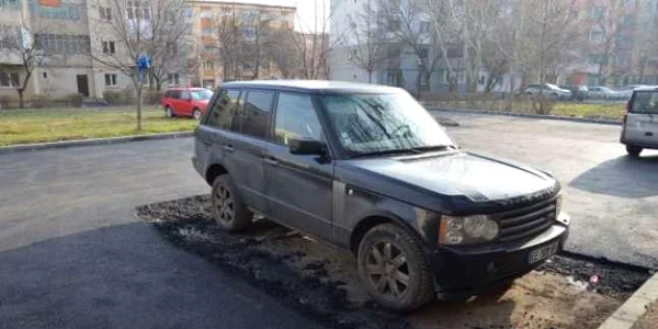 Muncitorii au turnat asfalt în jurul autoturismului