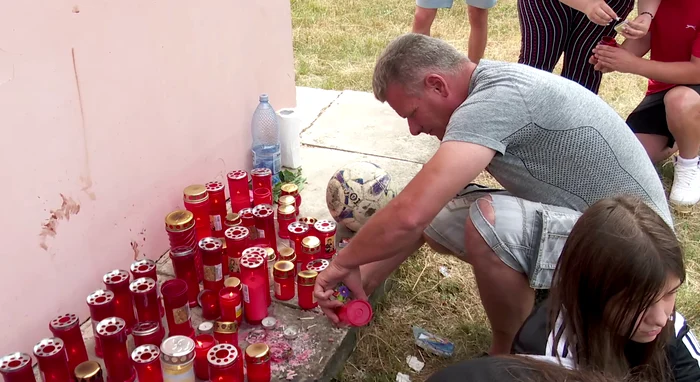 Oamenii aprind candele lângă zidul școlii din Cochirleanca. FOTO Iulian Bunilă