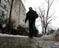 Un pieton circulă pe trotuarul acoperit cu gheaţă