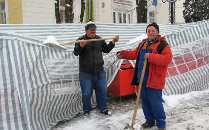 Botoşani: Muncitorii se chinuie să dea zăpada de pe corturi 