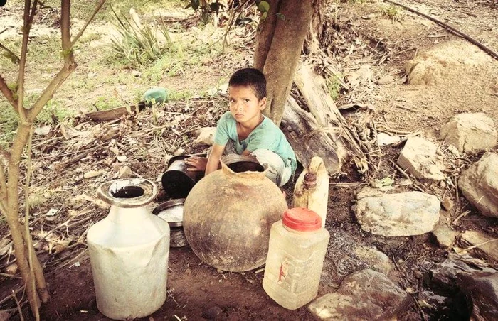 Copil din Nepal şi vasele în care se fac provizii de apă FOTO Ionuţ Ursu
