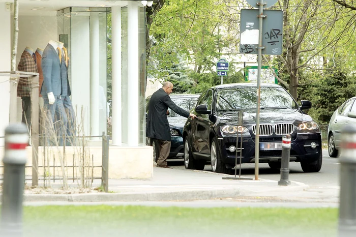 Unul dintre vânzători îi cară costumele la maşinăFoto: Mihai Ionescu