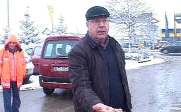 Primarul Ion Dumitru arată pietrele care au fost împrăştiate pe carosabil