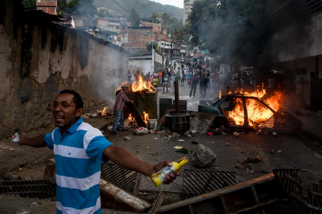 Caracas: Venezueleni protestând în vecinătatea sediului Gărzii Naţionale Bolivariene FOTO EPA-EFE