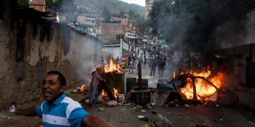 Oameni deomonstrează în vecinătatea sediului Gărzii Naţionale Bolivariene în Caracas Venezuela FOTO EPA-EFE / Miguel Gutierrez