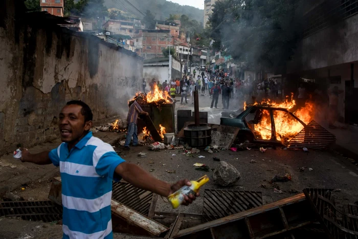 Caracas: Venezueleni protestând în vecinătatea sediului Gărzii Naţionale Bolivariene FOTO EPA-EFE