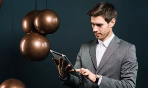 attractive young man using digital tablet with modern metal pendant jpg