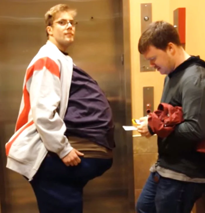 
    Băiatul care pare obez ține în brațe, pe sub hainele uriașe, un prietencaptură: youtube  