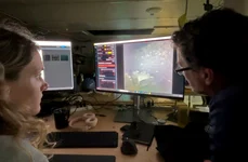 Specialiștii în imagistică WHOI, Dwight Coleman (dreapta) și Zoe Daheron, urmăresc cum imaginile în timp real ale epavei navei Quest sunt transmise de pe fundul mării (© Ken Kostel / Woods Hole Oceanographic Institution)
