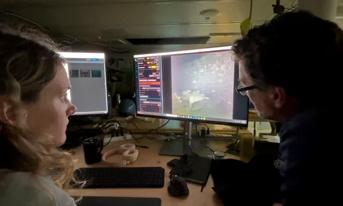 Specialiștii în imagistică WHOI, Dwight Coleman (dreapta) și Zoe Daheron, urmăresc cum imaginile în timp real ale epavei navei Quest sunt transmise de pe fundul mării (© Ken Kostel / Woods Hole Oceanographic Institution)