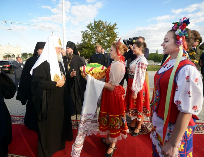 Patriarhul a fost întâmpinat de trei fete în costume naţionale rus, ucrainean şi „moldovenesc“ FOTO: Patriarch.ru