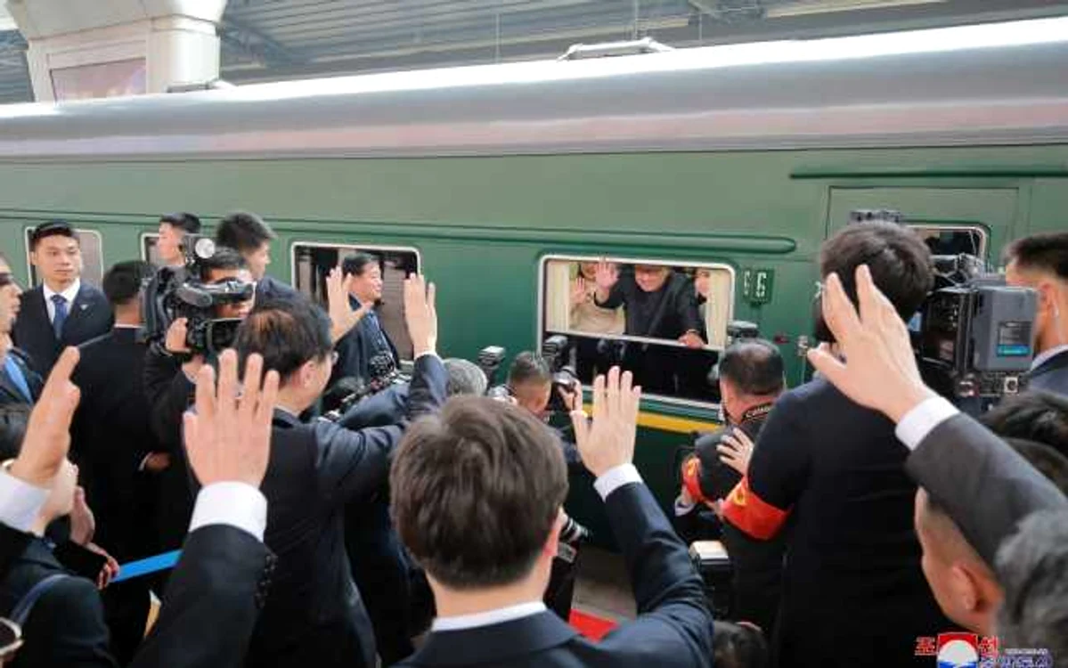 Kim Jong-un salută mulţimea de la bordul trenului care l-a adus la Beijing FOTO EPA-EFE