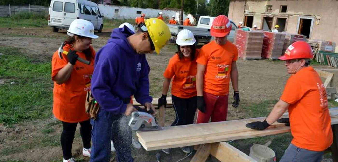 Sute de voluntari participa la ridicarea unei locuinte