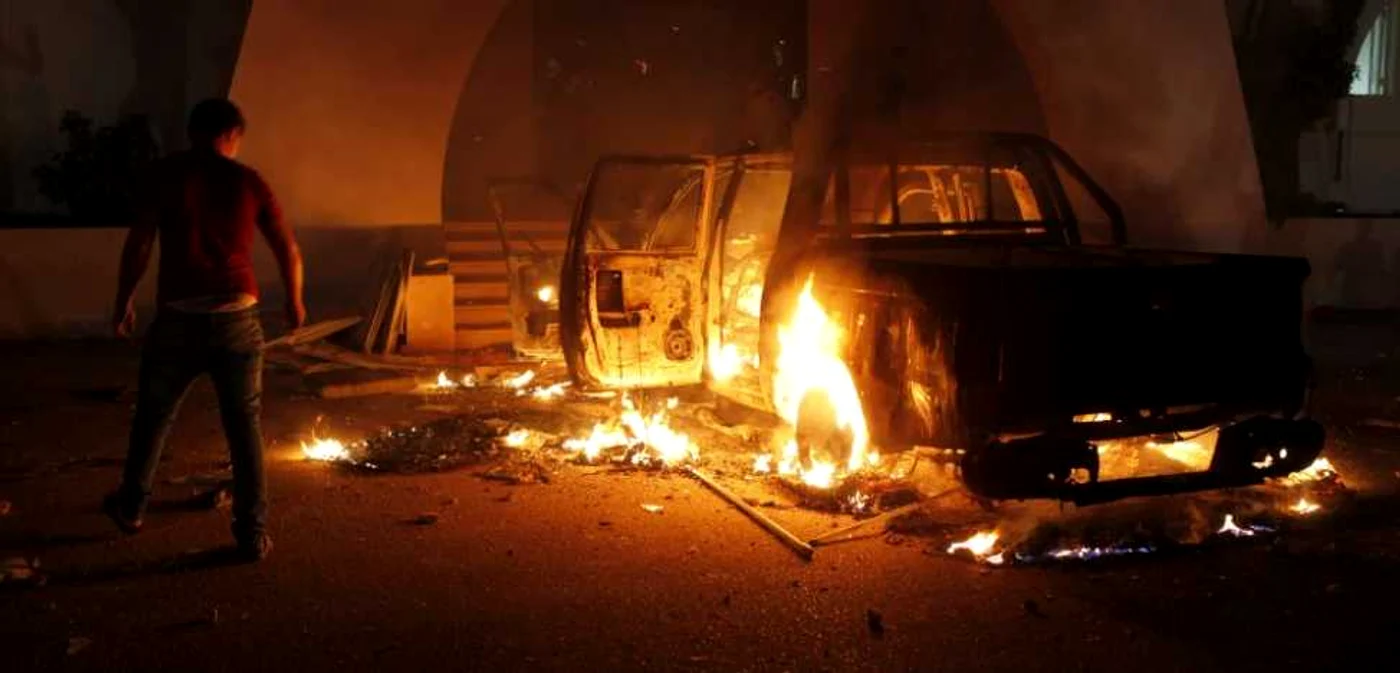 O maşină incendiată vineri seară, în faţa sediului fundamentaliştilor „Ansar al-Sharia” FOTO: Reuters