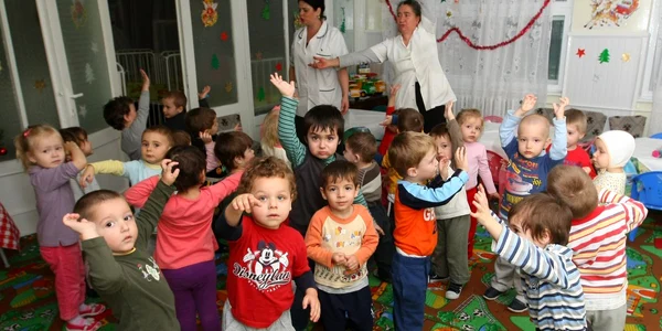 Cei 25 de prichindei se joacă printre mesele unde mănâncă