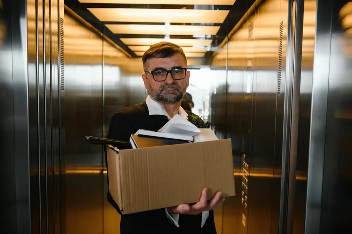 Doi bărbaţi şi două femei aşteaptă să intre la interviul de angajare