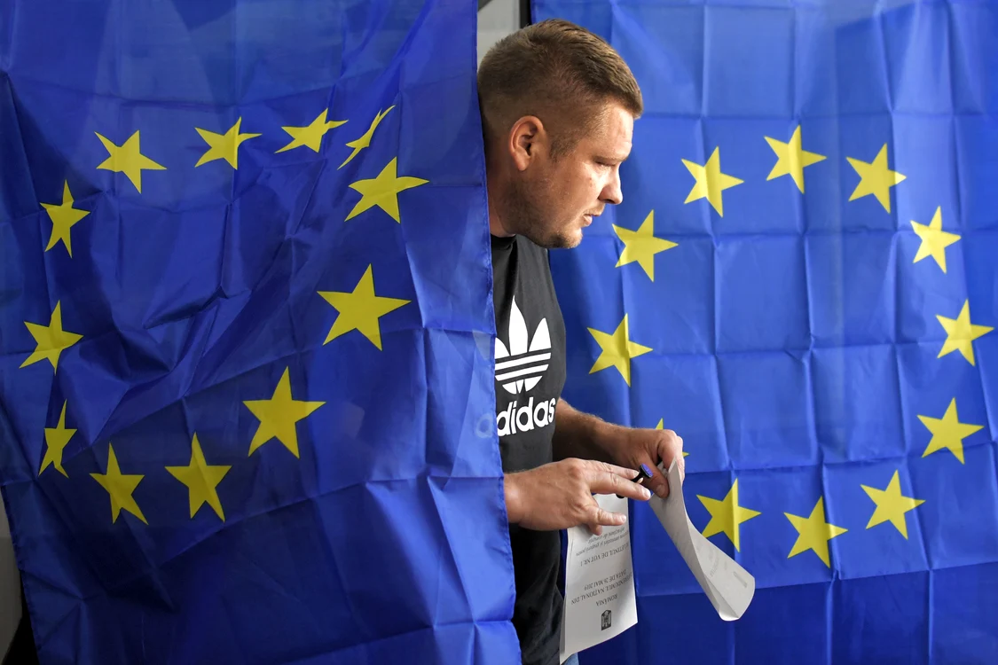 Tânăr ieșind din cabina de vot de la alegerile europarlamentare