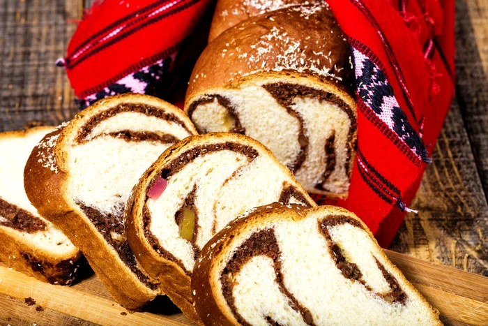 Slices of Romanian sponge cake with red traditional towel jpeg