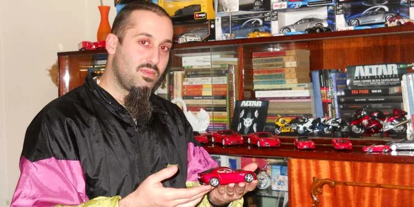 Damian Donca a aşteptat modelul de Alfa Romeo ce îl ţine în mână doi ani. În spate se află colecţia de Ferarri-uri. 