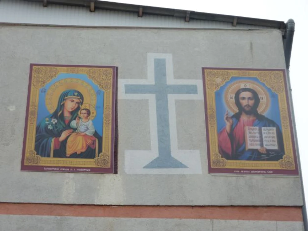 Trecătorii își fac cruce în dreptul icoanelor de pe bloc