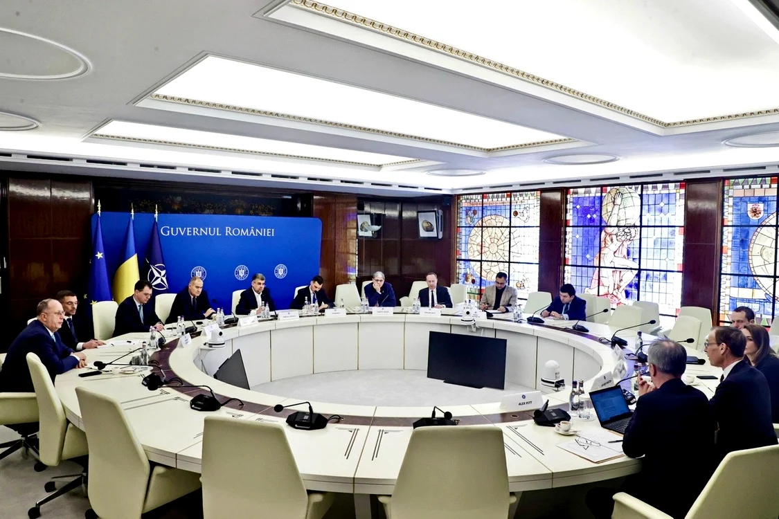 O masă rotundă la care stau oficiali din Guvernul României și ai delegației FMI