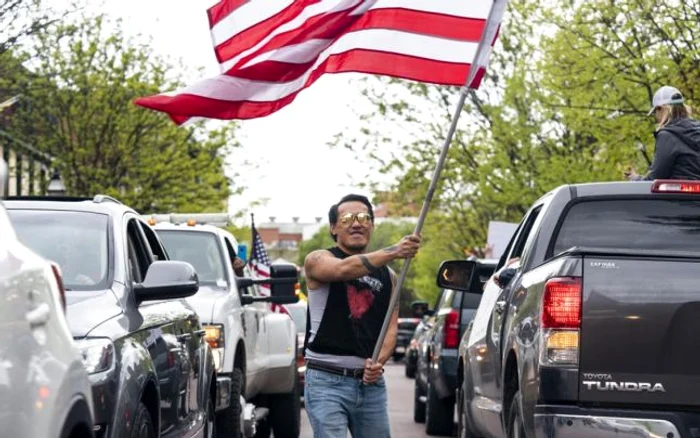 Un protestatar fluturând steagul SUA la manifestaţia din Annapolis, Maryland FOTO EPA-EFE