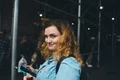 femeie zambitoare cu smartphone in mana jpg