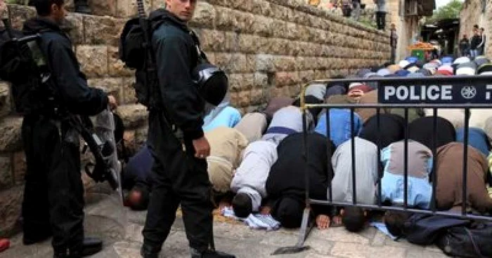 Poliţia israeliană păzeşte un grup de palestinieni care se roagă în Ierusalimul de Est