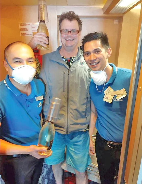 Pasagerul Paul Turner, împreună cu membrii echipajului, care poartă măşti