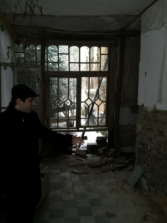 Preotul Cristian Borz, prezentând dezastrul din casa memorială Iuliu Maniu