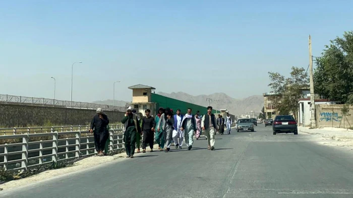 Un grup de afgani îndreptându-se către aeroportul internaţional din Kabul FOTO EPA-EFE