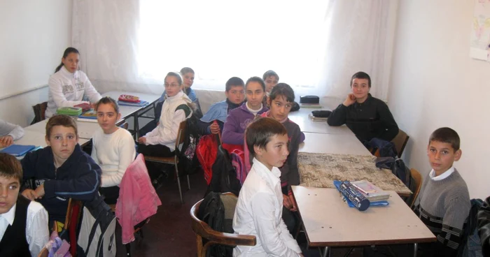 Copiii se strecoară cu greu printre bănci, pentru a ieşi la tablă. Foto: Bogdan Nistor