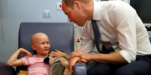 Prinţul William Duce de Cambridge discută cu pacienta Daisy Wood în vârstă de 6 ani în timpul unei vizite la spitalul Royal Marsden în Sutton Anglia FOTO Guliver / Getty Images / Kirsty Wigglesworth