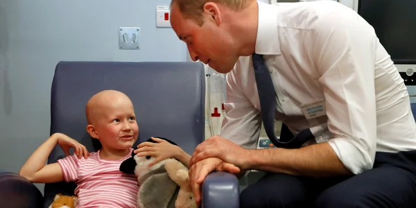 Prinţul William Duce de Cambridge discută cu pacienta Daisy Wood în vârstă de 6 ani în timpul unei vizite la spitalul Royal Marsden în Sutton Anglia FOTO Guliver / Getty Images / Kirsty Wigglesworth