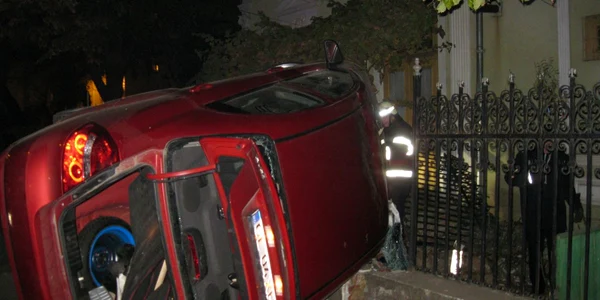 Maşina poliţistului a rupt gardul şi s-a răsturnat. 