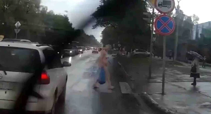 Femeia complet goală a traversat strada fără să-i pese de privirile celor din jur