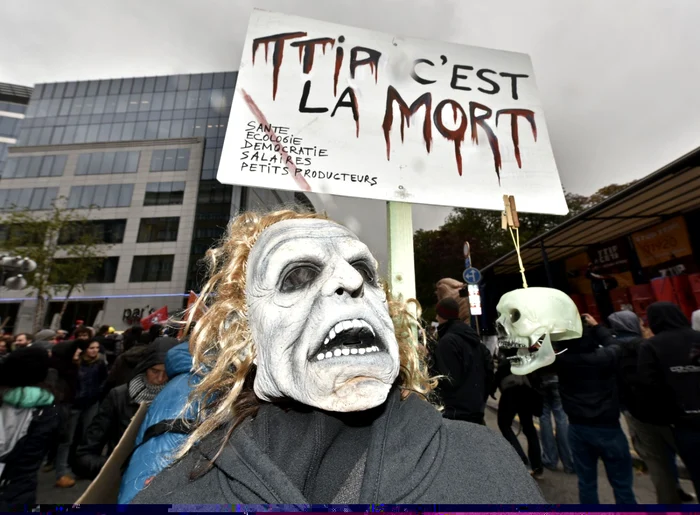 Un protestatar cu o mască pe faţă demonstrează împotriva Acordului de liber schimb TTIP (Transatlantic Comerţ şi Parteneriatul de Investiţii) în timpul summitului UE de la Bruxelles