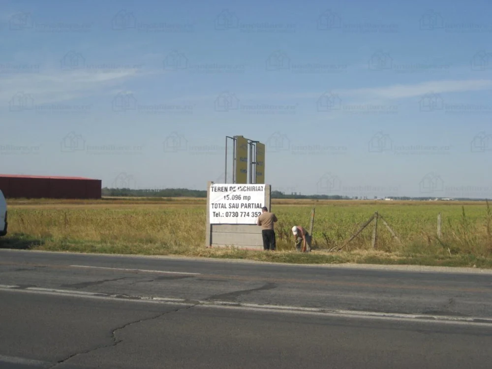 Afiș pe marginea drumului pe care scrie Teren de Vânzare