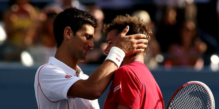 Novak Djokovic îl consolează pe Stanislas Wawrinka. FOTO: AFP