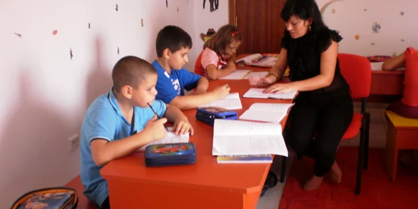 Copiii îşi fac lecţiile îndrumaţi de personal calificat