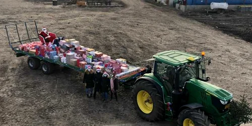 Moş Crăciun a venit cu un tractorul încărcat cu cadouri la copiii din comuna Berlişte