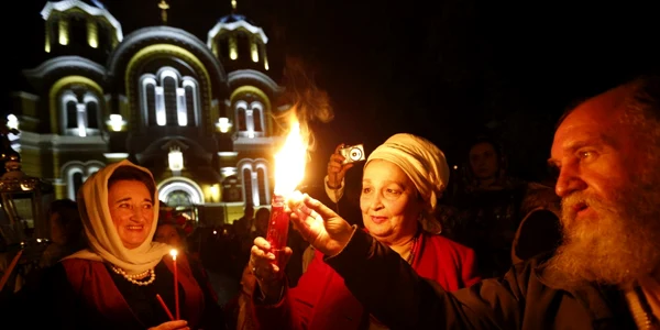 Credincioşi creştini ortodocşi ucrainieni iau lumină din Focul Sfânt adus de la Ierusalim la Catedrala Sf Volodymyr în timpul ceremoniei religioase de Paşte la Kiev Ucraina FOTO AP